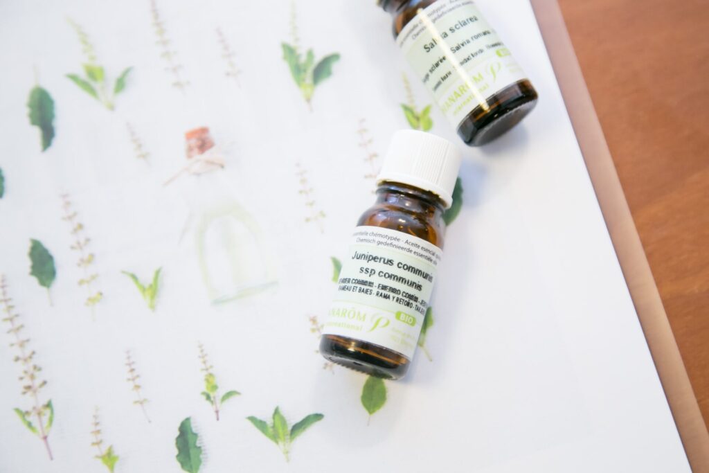 精油ボトルとハーブのイラストが並んだ写真