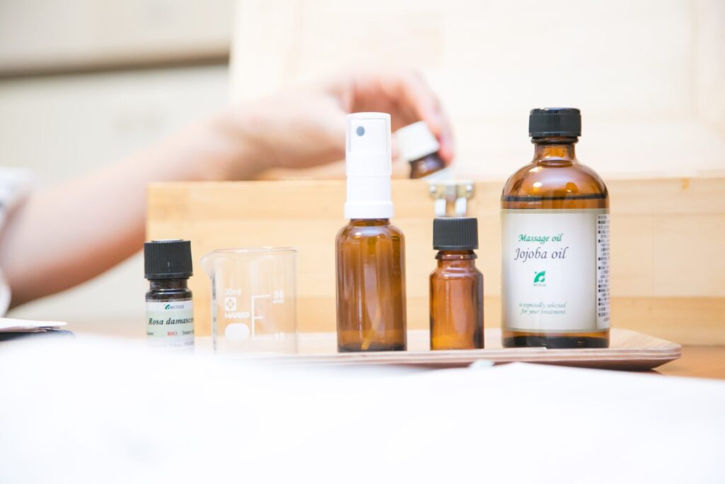 精油ボトルとキャリアオイル、計量器具などアロマテラピーに使用する道具がトレーに並んでいる様子