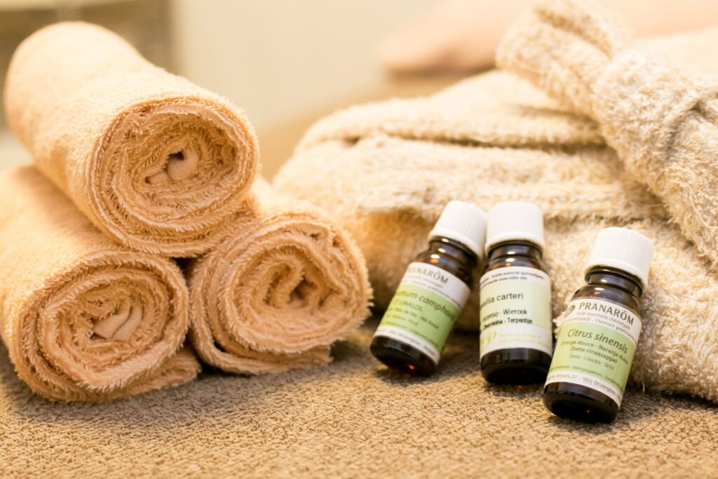 トリートメントに使用する精油ボトルとタオルの写真