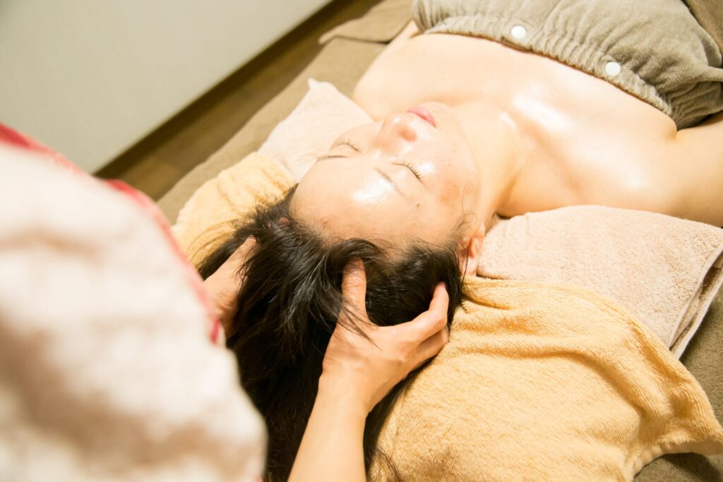 ヘッドトリートメント講座で頭部の施術を学んでいる様子