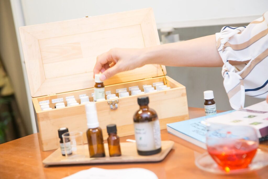 講師が精油ボックスから精油を取り出している授業中の手元の様子