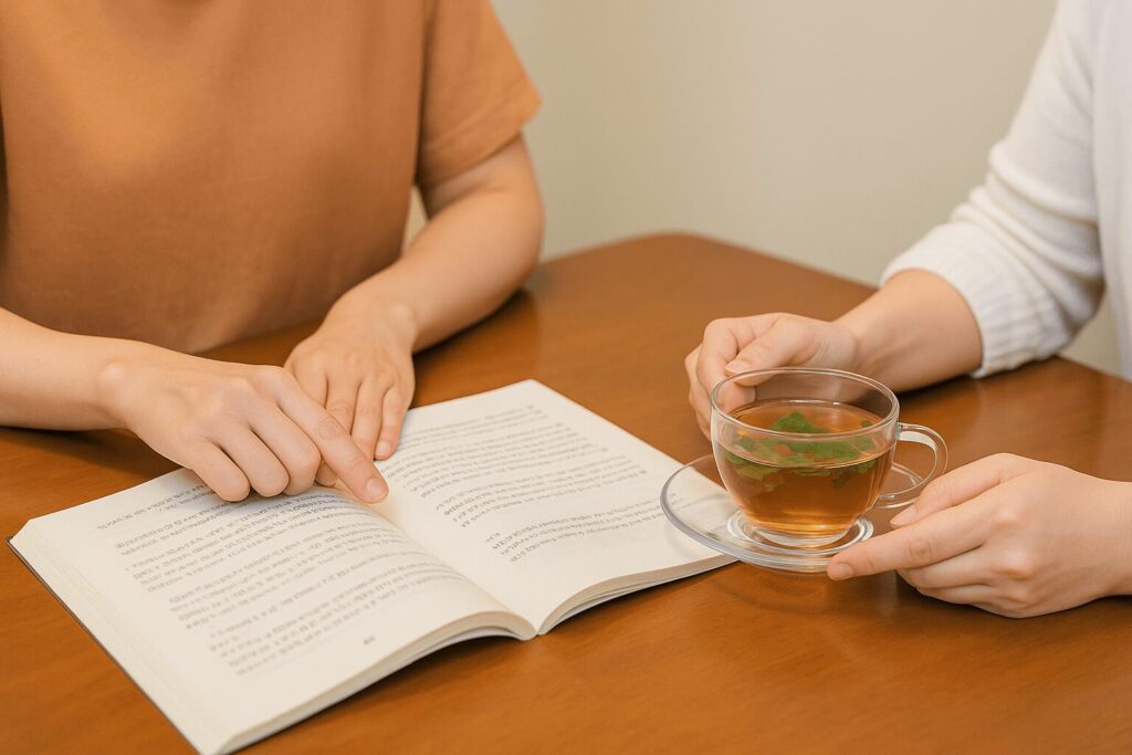 精油とテキストを前に講師と受講生が向かい合っている一対一のアロマレッスンの様子の手元写真