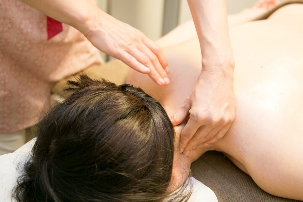 首筋の筋肉を丁寧にほぐすアロマボディトリートメント施術の様子