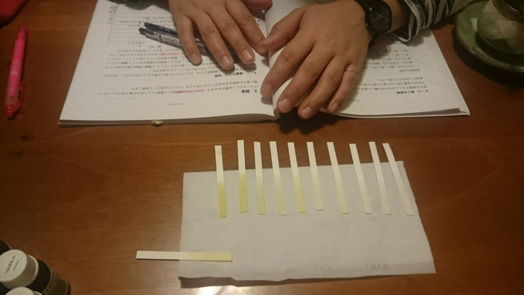 アロマのレッスンでムエットに精油を染み込ませ、資料を見ながら学習している手元の様子