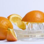 オレンジを搾っている様子を写した写真。柑橘の精油を説明するイメージ画像。