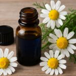 カモマイル・ジャーマン精油の青色オイル瓶と白い花