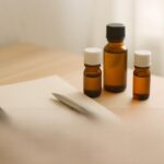 ノートと精油瓶が並ぶ落ち着いた雰囲気のイメージ写真