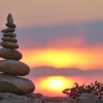 積み重ねた石と朝日の風景｜21日間の継続と習慣化を象徴するイメージ