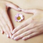 お腹に手を添え花を置いたSS健康法のイメージ写真